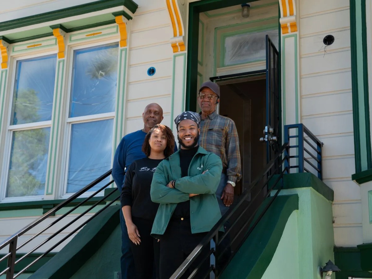 Four people of different ages stand on a stoop.