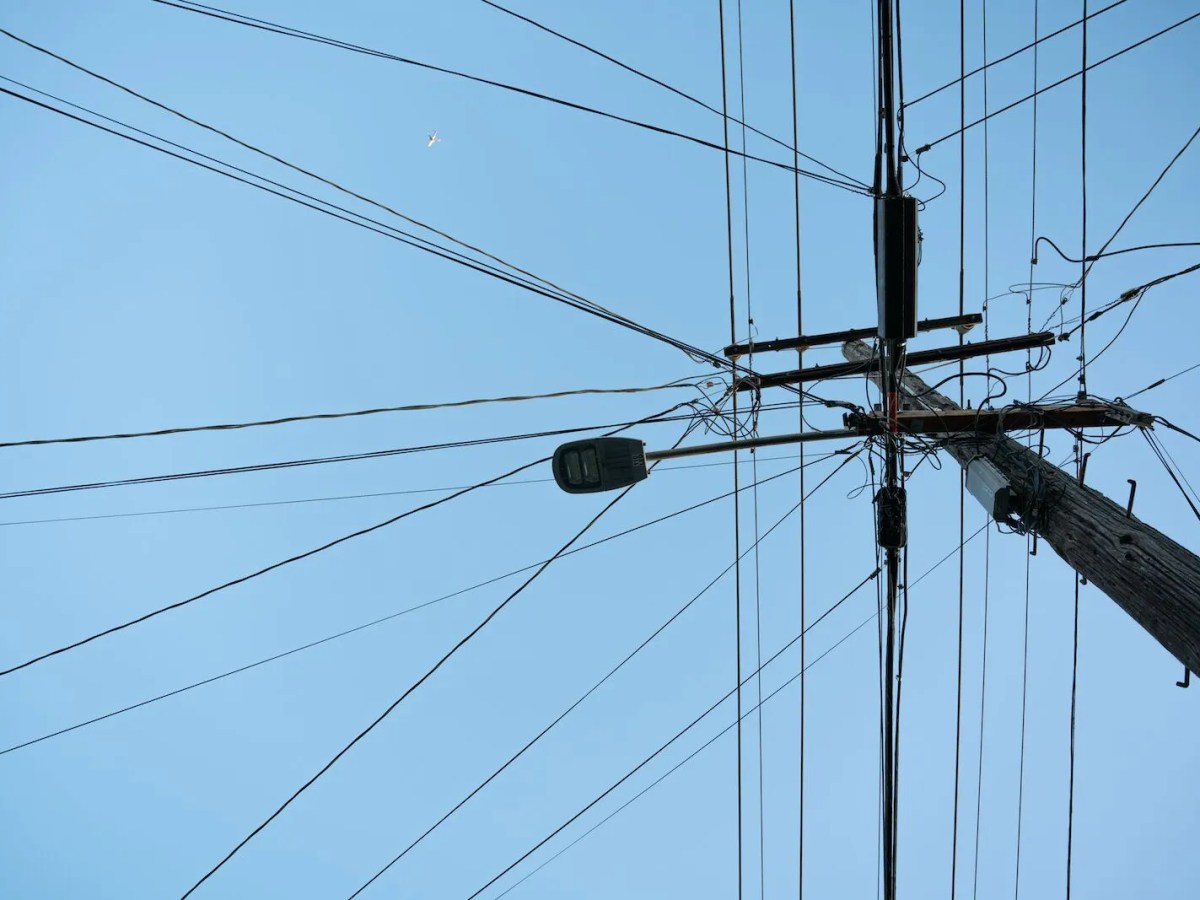 A tangle of utility wires against a clear sky.