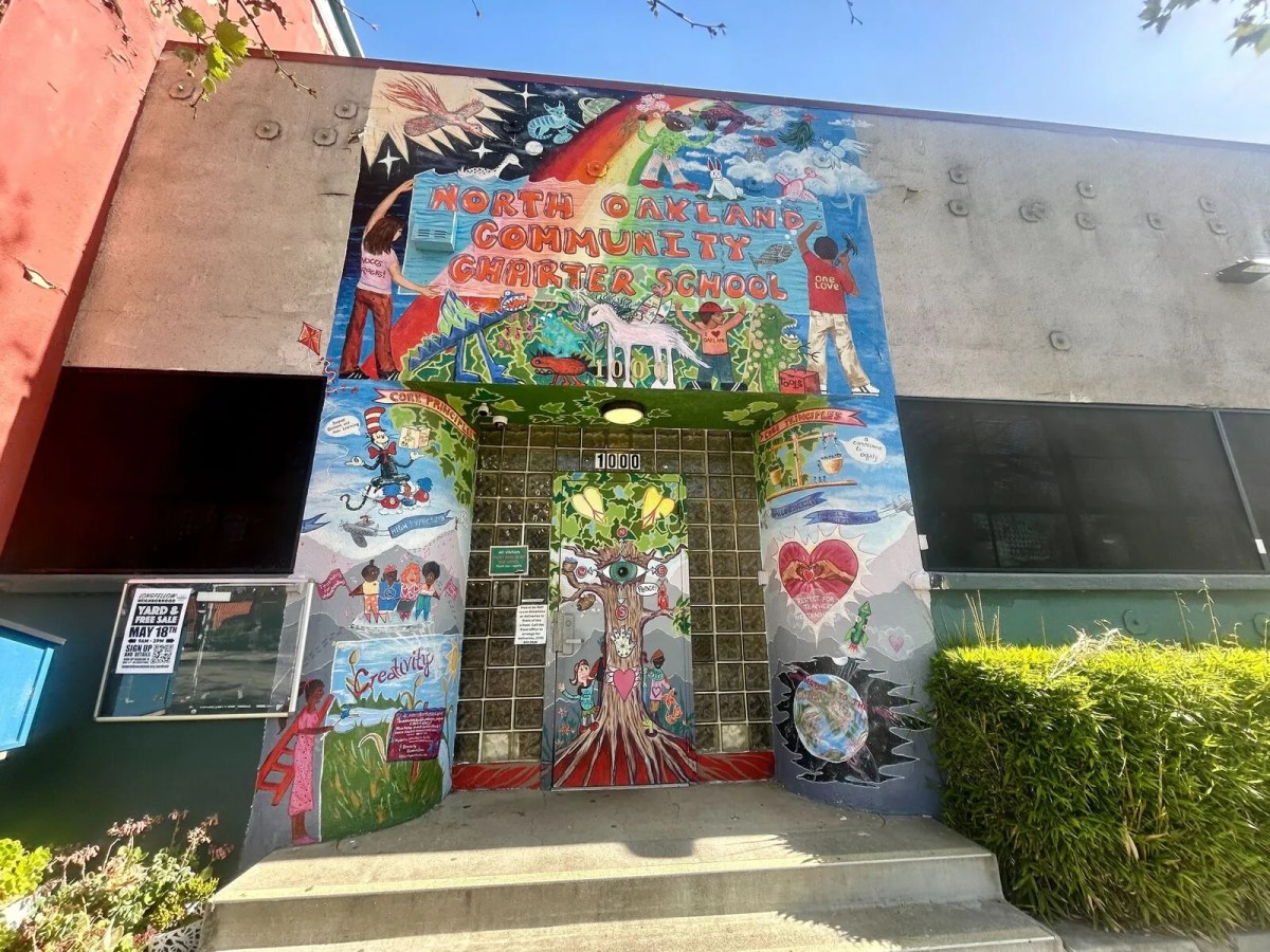 The entrance to North Oakland Community Charter School, a doorway framed by a beautiful, hand-painted, colorful mural.