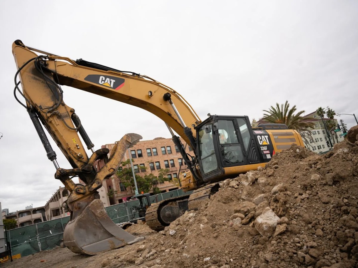 A bulldozer scoops a big mound of dirt.