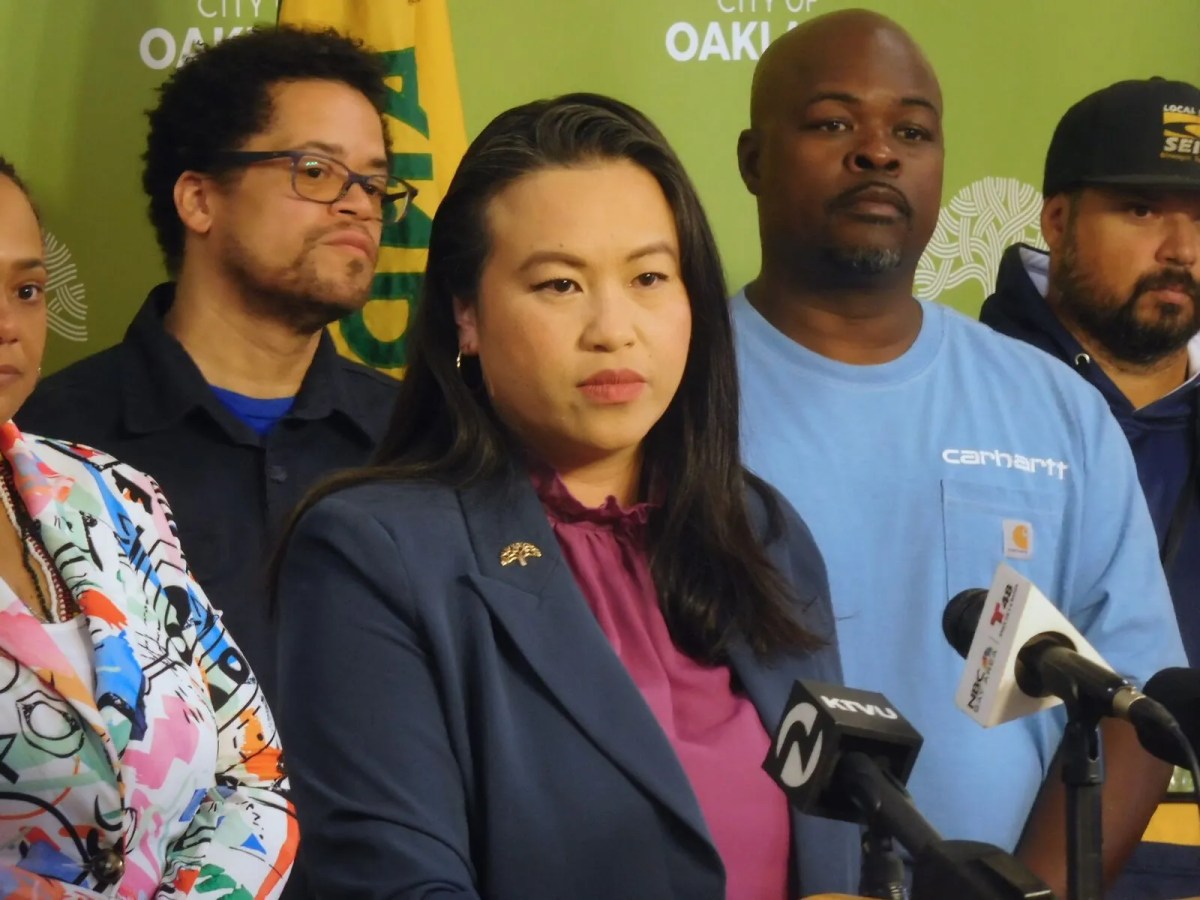 Oakland Mayor Sheng Thao standing before city workers at a press conference.