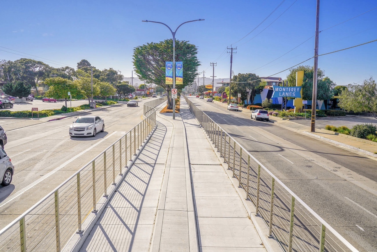 What 73rd Avenue might look like after a resdesign: a major road with a bike lane down the middle that is protected by fences.
