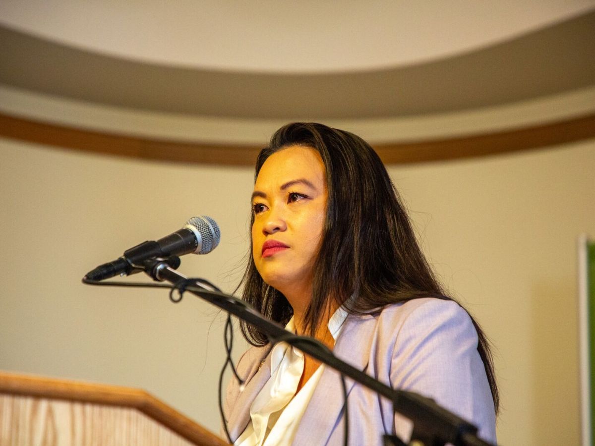 Oakland Mayor Sheng Thao in front of a podium with a microphone