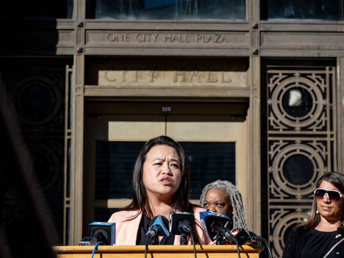 Sheng Thao, looking concerned, speaks at a podium outdoors.