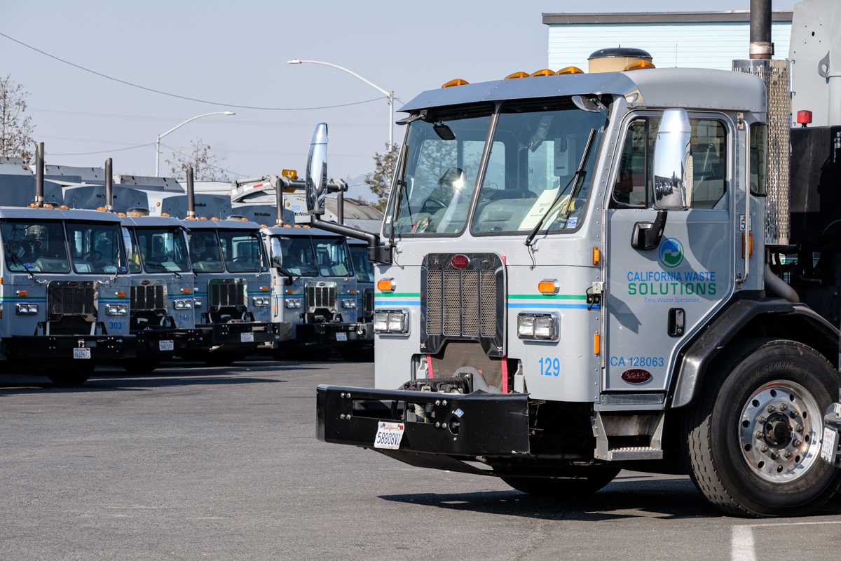 Several California Waste Solutions trucks.